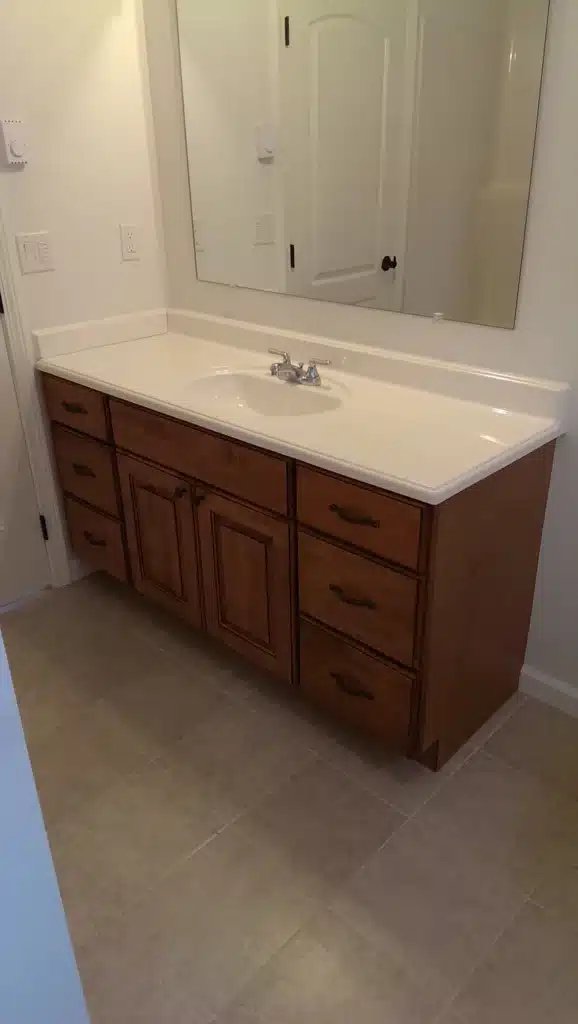 Bathroom vanity with wood cabinets and solid-surface countertop in Hillsboro, Oregon
