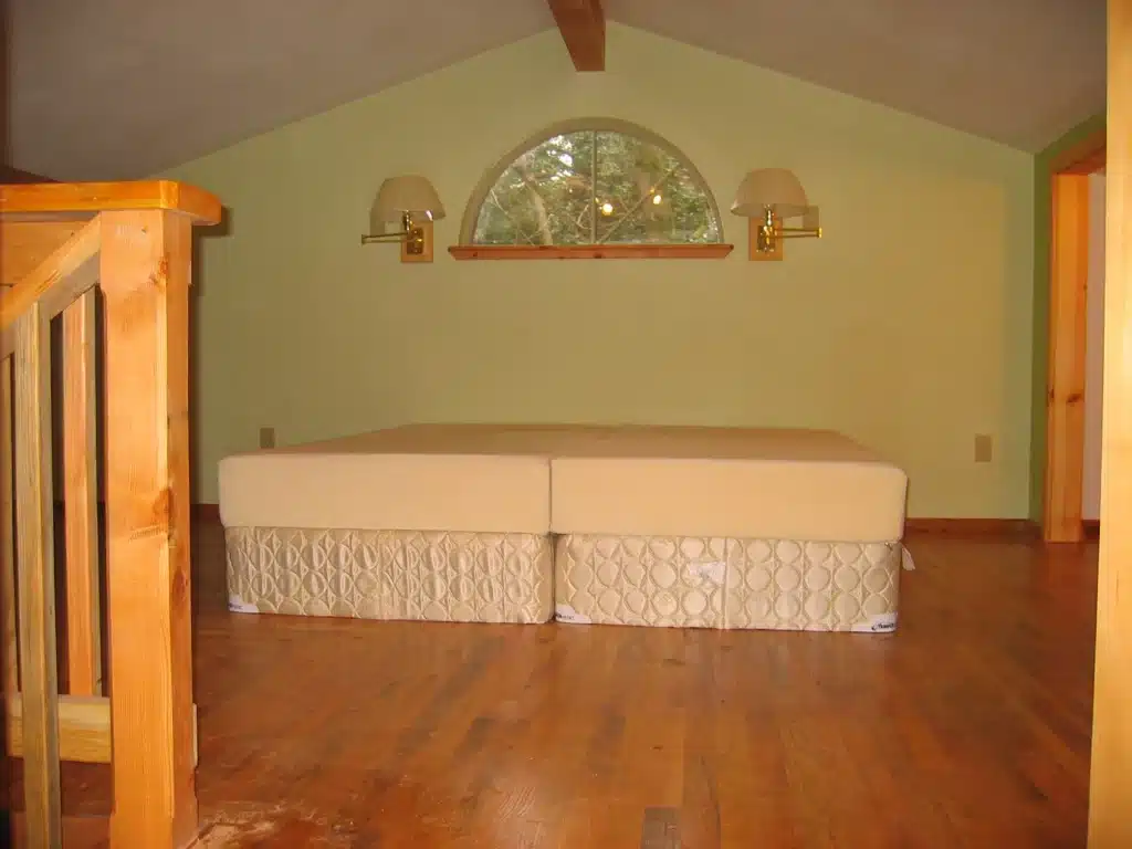 Bedroom loft featuring new hardwood flooring and custom railing