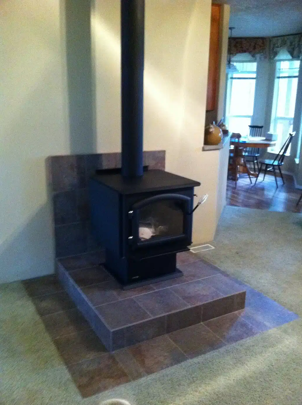 Completed hearth and tile backing behind installed wood stove