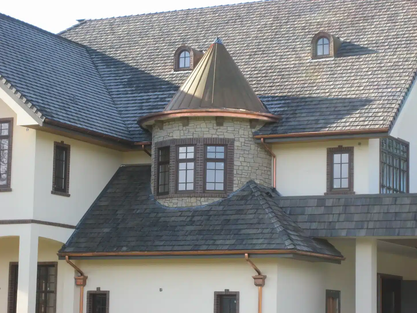 Close-up of finished stone turret with copper roof and custom window trim in Newberg, Oregon