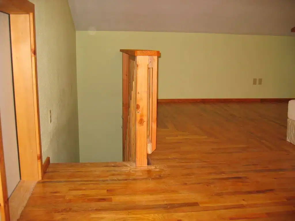 Loft landing with hardwood flooring and staircase railing