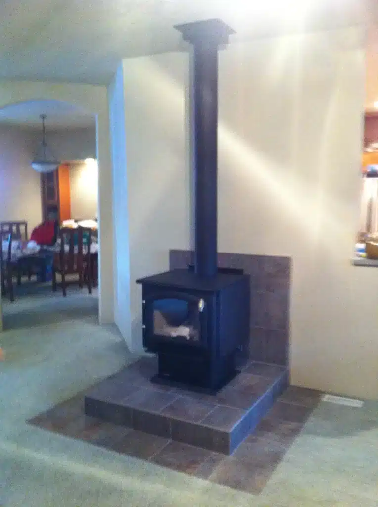 Wood stove with full tile surround in remodeled Tigard living space