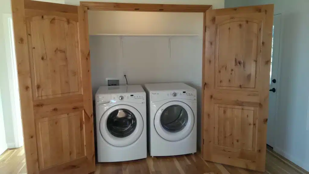 Laundry appliances inside wood-trimmed closet in Hillsboro, Oregon