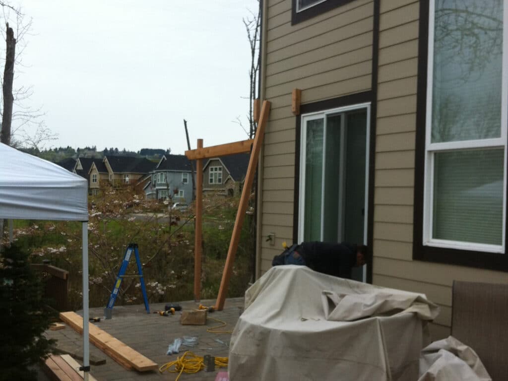 Cedar pergola construction in progress on a residential patio in Wilsonville, Oregon