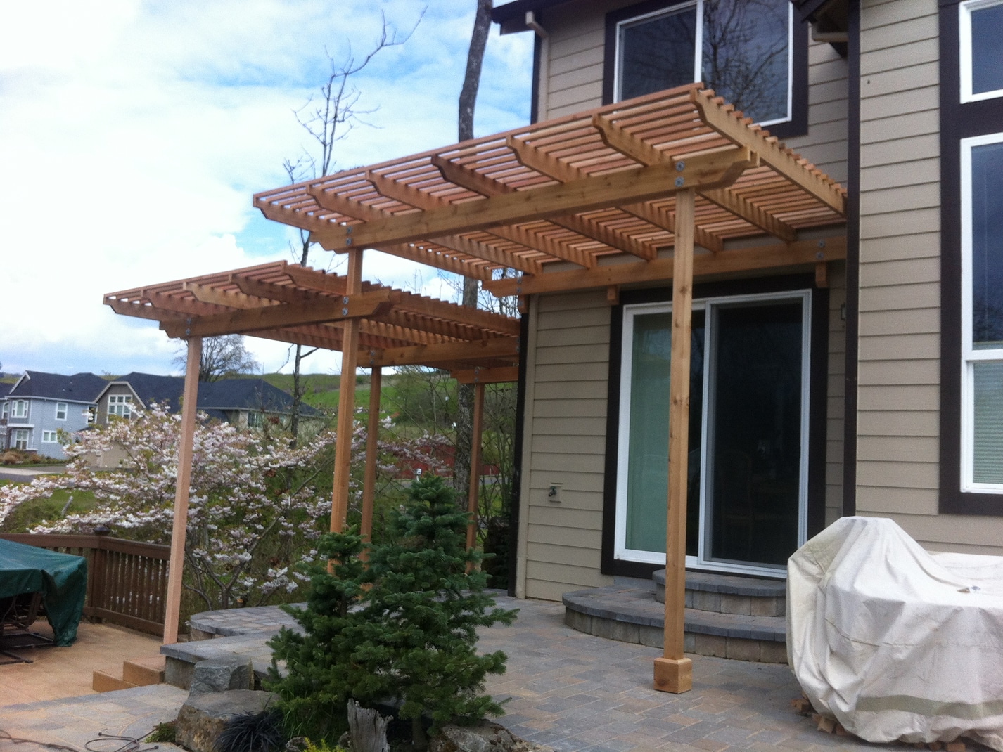 Backyard cedar pergola addition connected to a two-story home in Wilsonville, Oregon