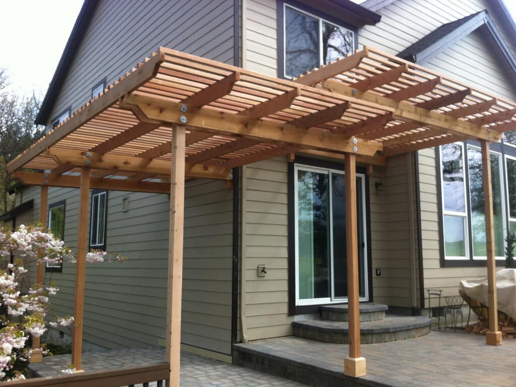 Cedar pergola attached to a home patio with a slatted roof design in Wilsonville, Oregon