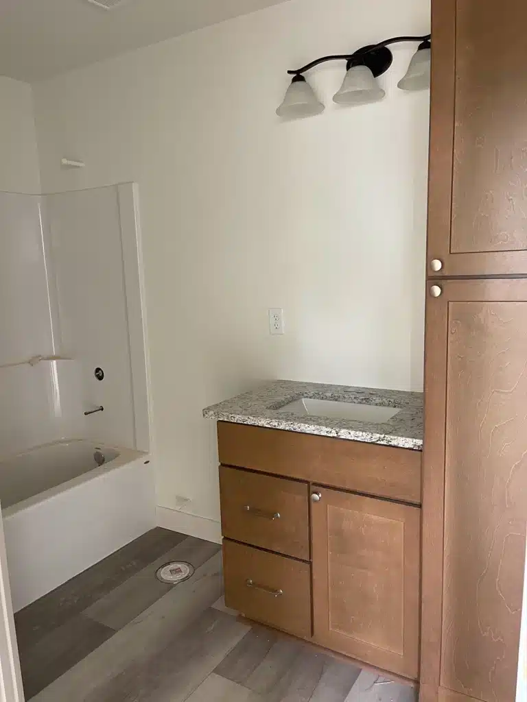 Bathroom with new granite vanity and tub in duplex project