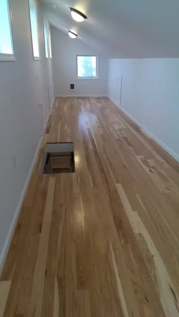 Finished attic room with hardwood floors and white walls in Hillsboro, Oregon