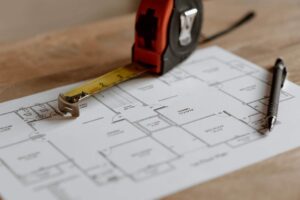 Blueprint with measuring tape and pen